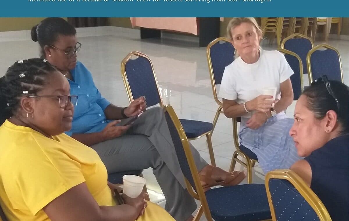 Members seated in an informal circle at the Baie Ste Anne community centre on Praslin, some taking notes.