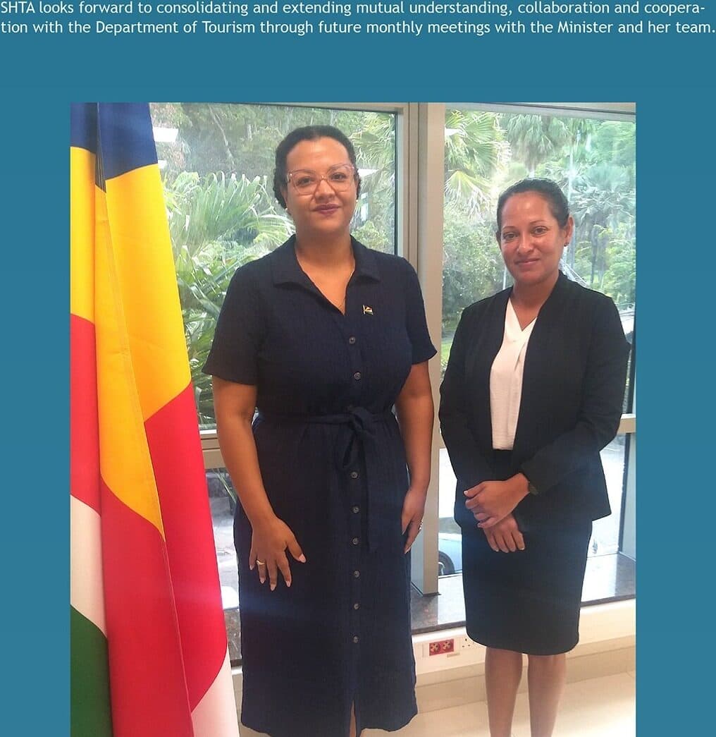 Minister Amanda Bernstein and SHTA Chairperson Shamita Palit standing beside the Seychelles flag.